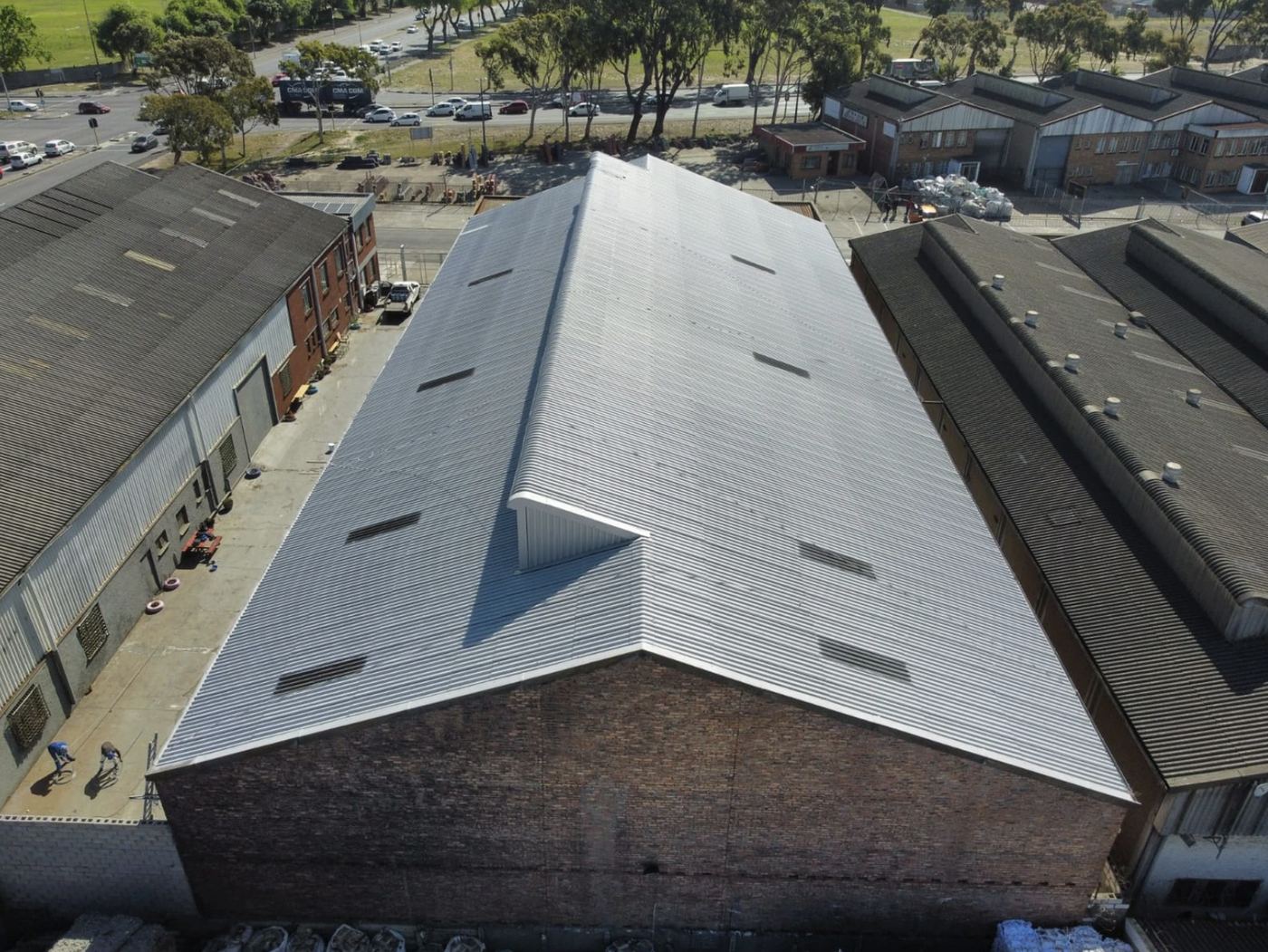 Brick-gabled warehouse roof sealed in an industrial area