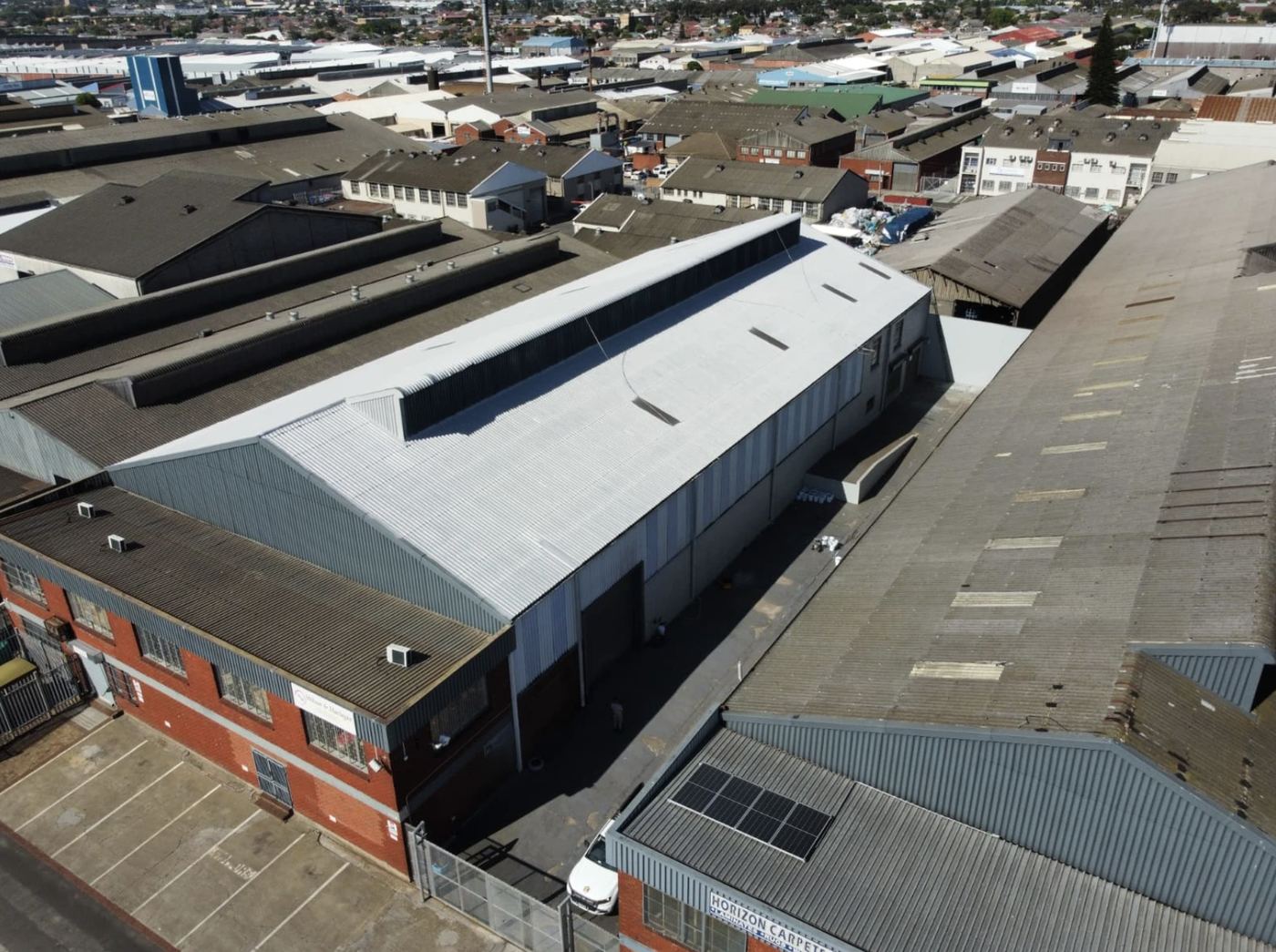 Factory roof encapsulated among neighbouring asbestos roofs