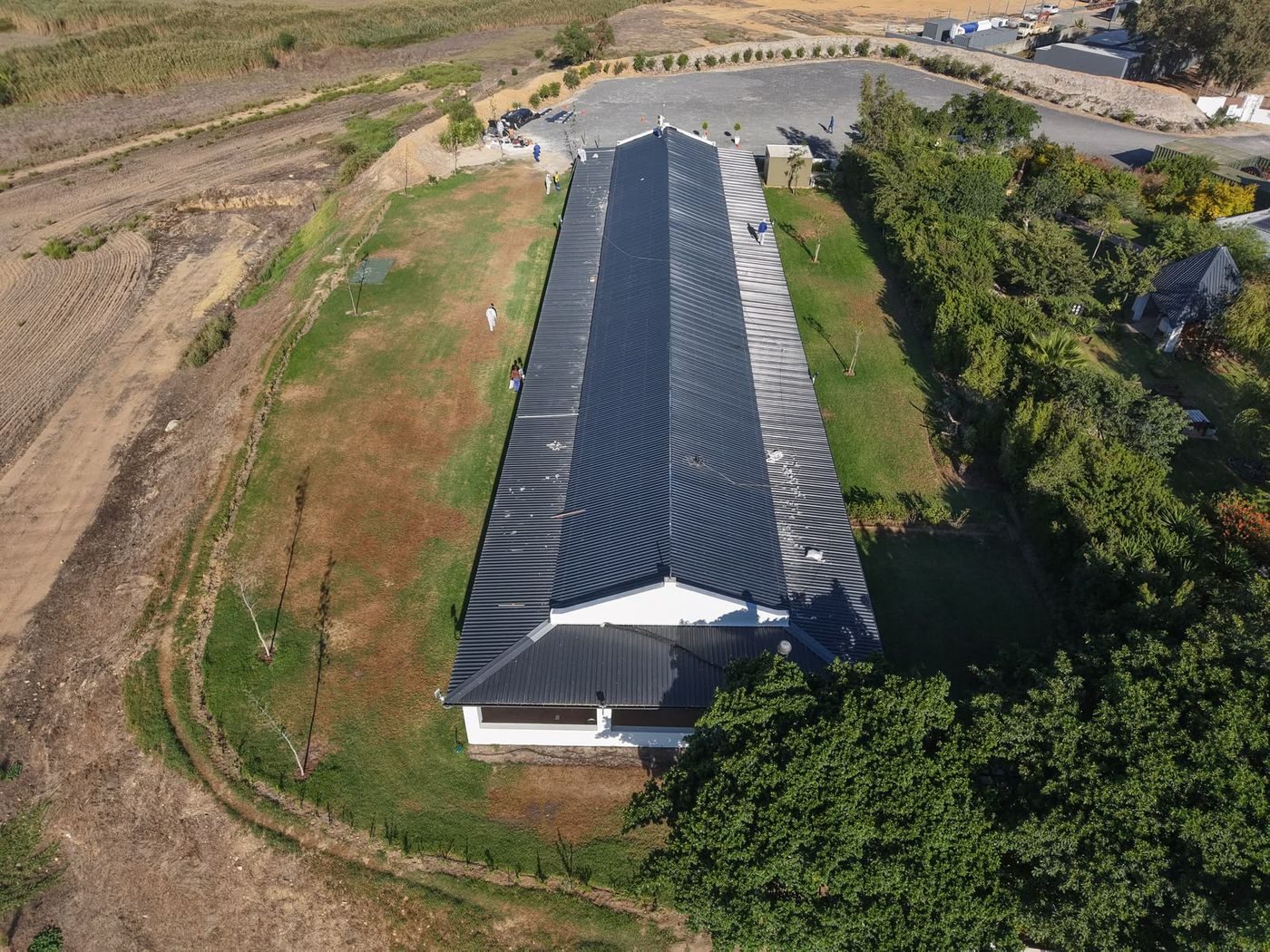 Cape Asbestos Solutions team coating a long farm building roof